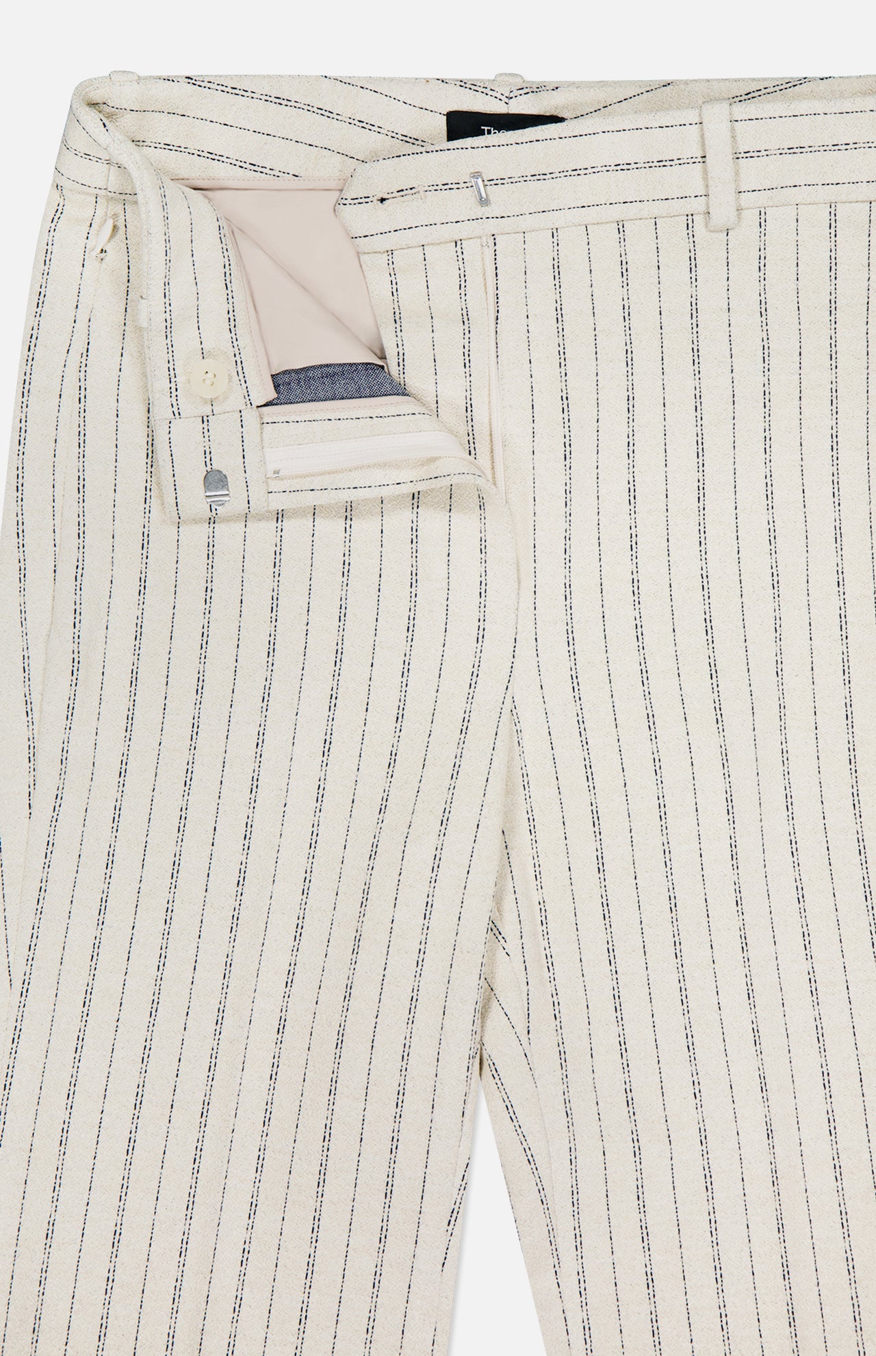 A close-up of the THEORY Slim Full Length Trouser Pant in cream with thin black pinstripes, featuring a partially unzipped front that reveals the waistband, button, and part of the zipper.