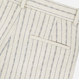 Close-up of THEORY's Slim Full Length Trouser Pant, beige with vertical navy pinstripes in crepe fabric, featuring a back welt pocket, belt loops, and detailed stitching.