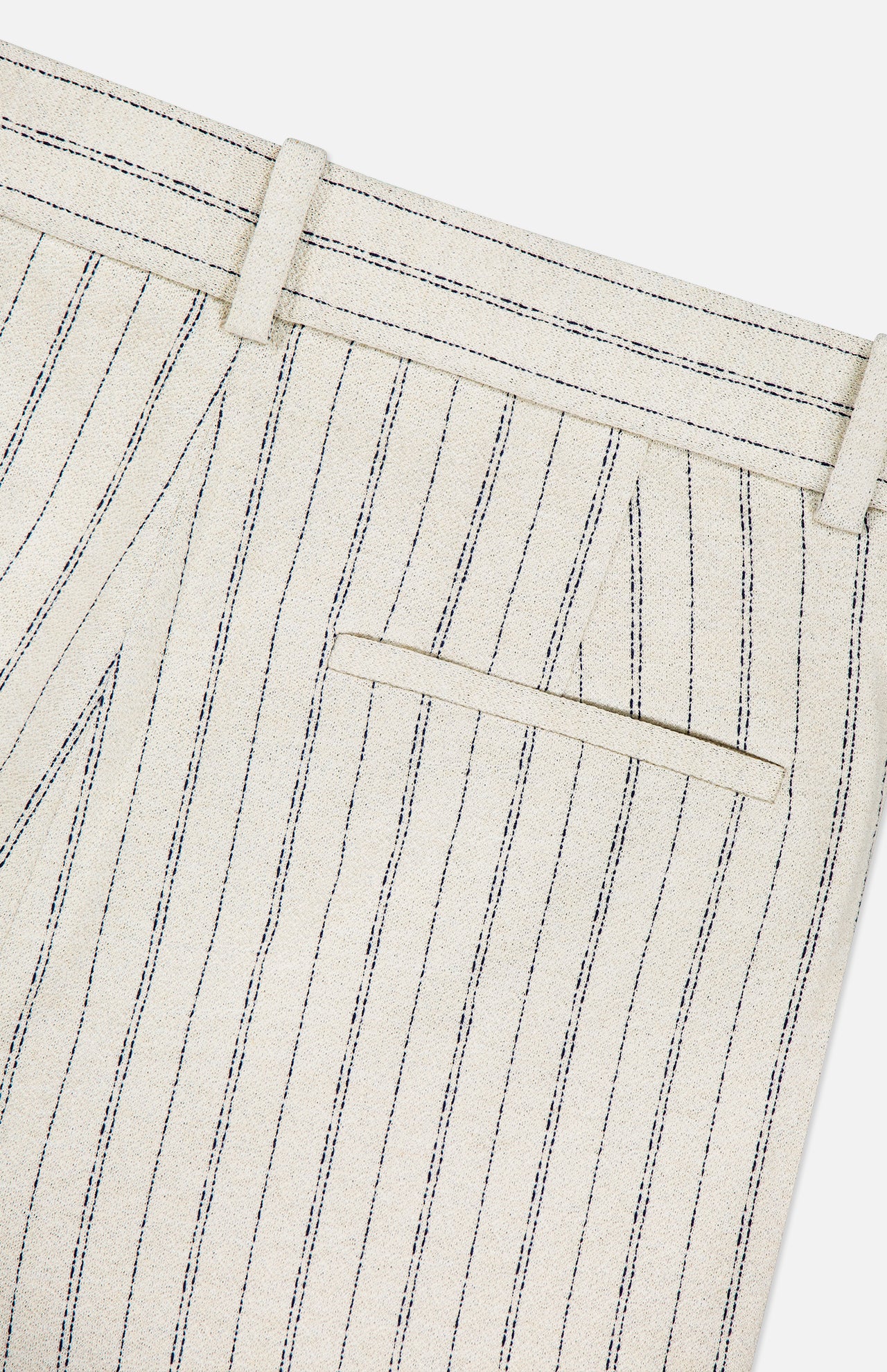 Close-up of THEORY's Slim Full Length Trouser Pant, beige with vertical navy pinstripes in crepe fabric, featuring a back welt pocket, belt loops, and detailed stitching.