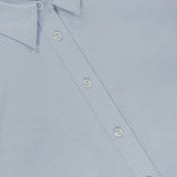 Close-up of the THEORY Tailored Cutaway Shirt in light blue, a slim-fit button-up featuring white buttons, a pointed collar, and a subtle cutaway hem, shown laying flat.