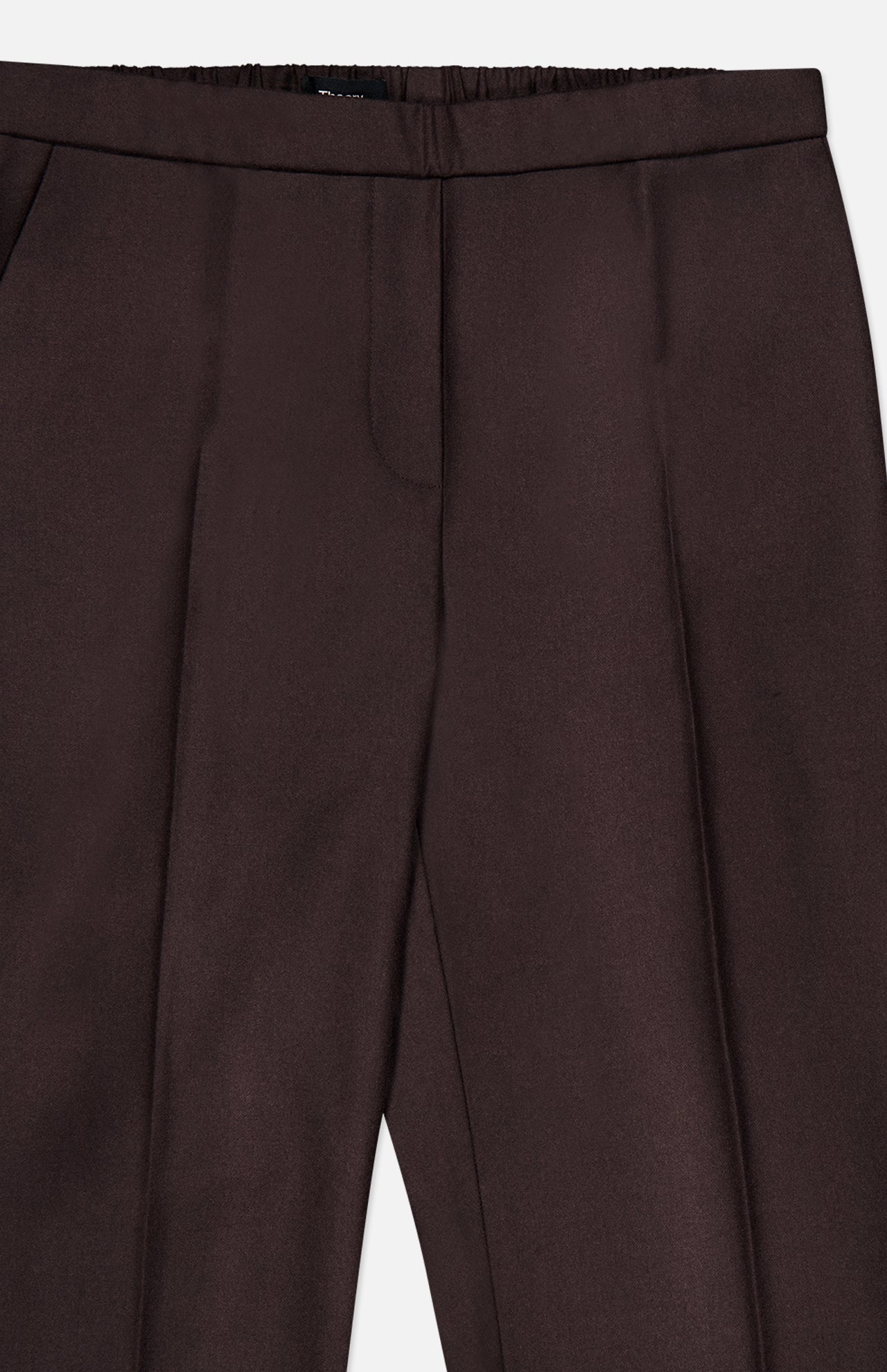 The Treeca Pull-On Pant by THEORY features a dark brown tailored design with a smooth front, side pockets, and subtle crease lines down each leg. These slim fit wool pants are perfect for office wear, offering both style and comfort with a partially elasticized waistband at the back.