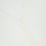 Close-up of an off-white Volume Sleeve Silk Blouse from THEORY, showing the V-neckline, part of the collar, and a black label with the brand name THEORY and size 4.