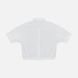 Back view of the THEORY Yoke Elastic Short Sleeve Shirt in white, featuring a cropped elastic hem and buttoned cuffs. Displayed on a plain white background—ideal for casual travel wear.