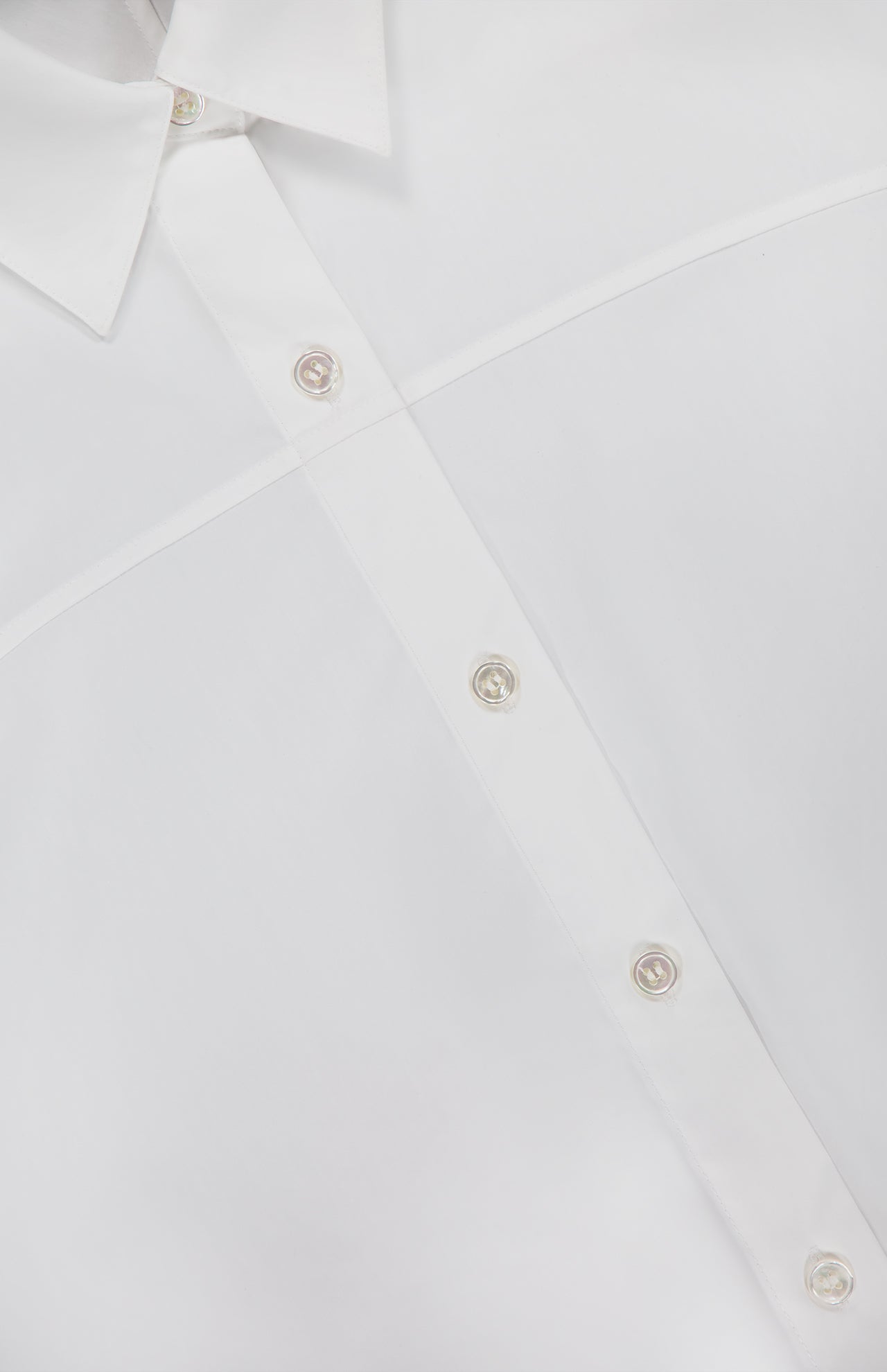 Close-up of the THEORY Yoke Elastic Short Sleeve Shirt in white, highlighting part of the collar, front buttons, and a distinctive diagonal seam across the fabric.
