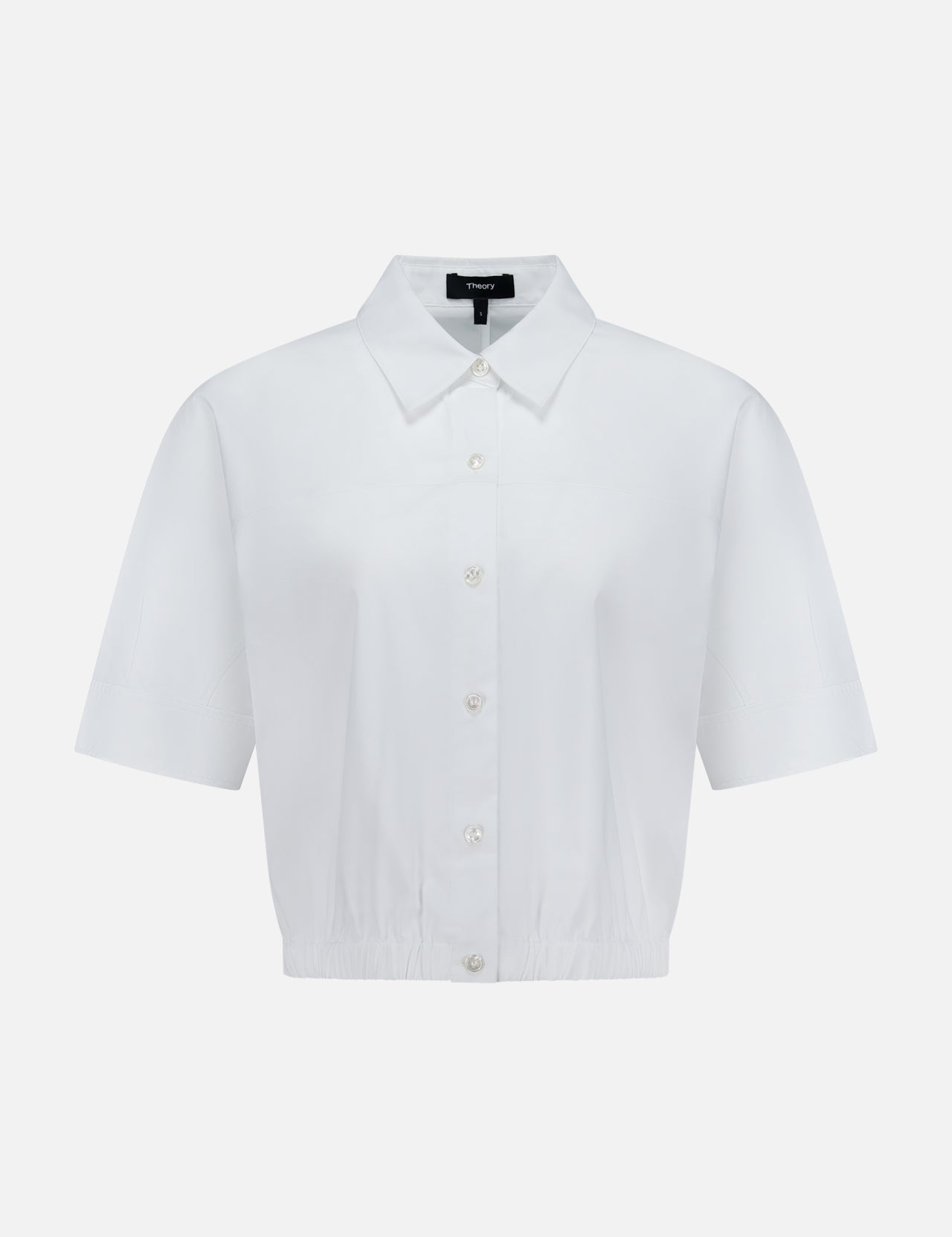 The THEORY Yoke Elastic Short Sleeve Shirt features a button-up front, collar, and slightly cropped elastic hem in white—ideal for casual travel. Shown on a plain white background.