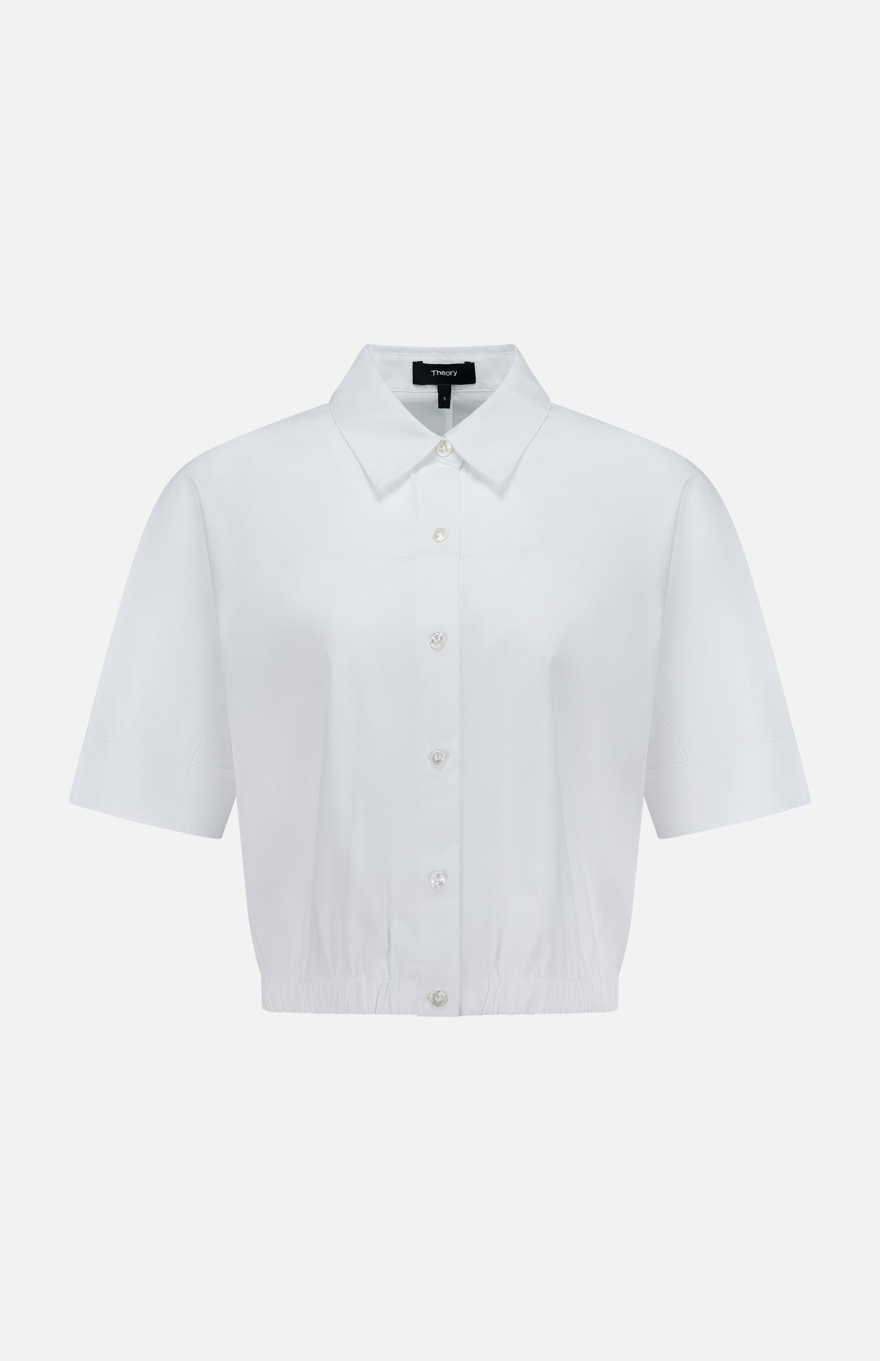 The THEORY Yoke Elastic Short Sleeve Shirt features a button-up front, collar, and slightly cropped elastic hem in white—ideal for casual travel. Shown on a plain white background.