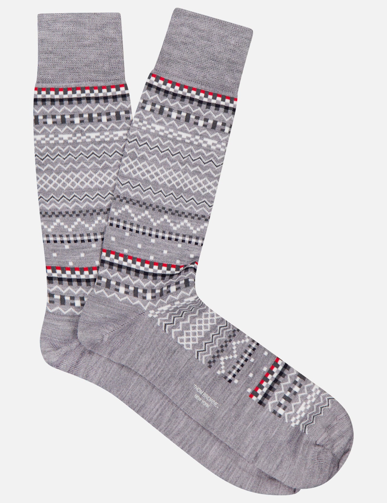 THOM BROWNE Merino Wool Fairisle Jacquard Mid Calf Socks in gray, featuring a geometric pattern with black, white, red, and light gray zigzags and dots. Displayed side by side on a white background. Made in the USA.
