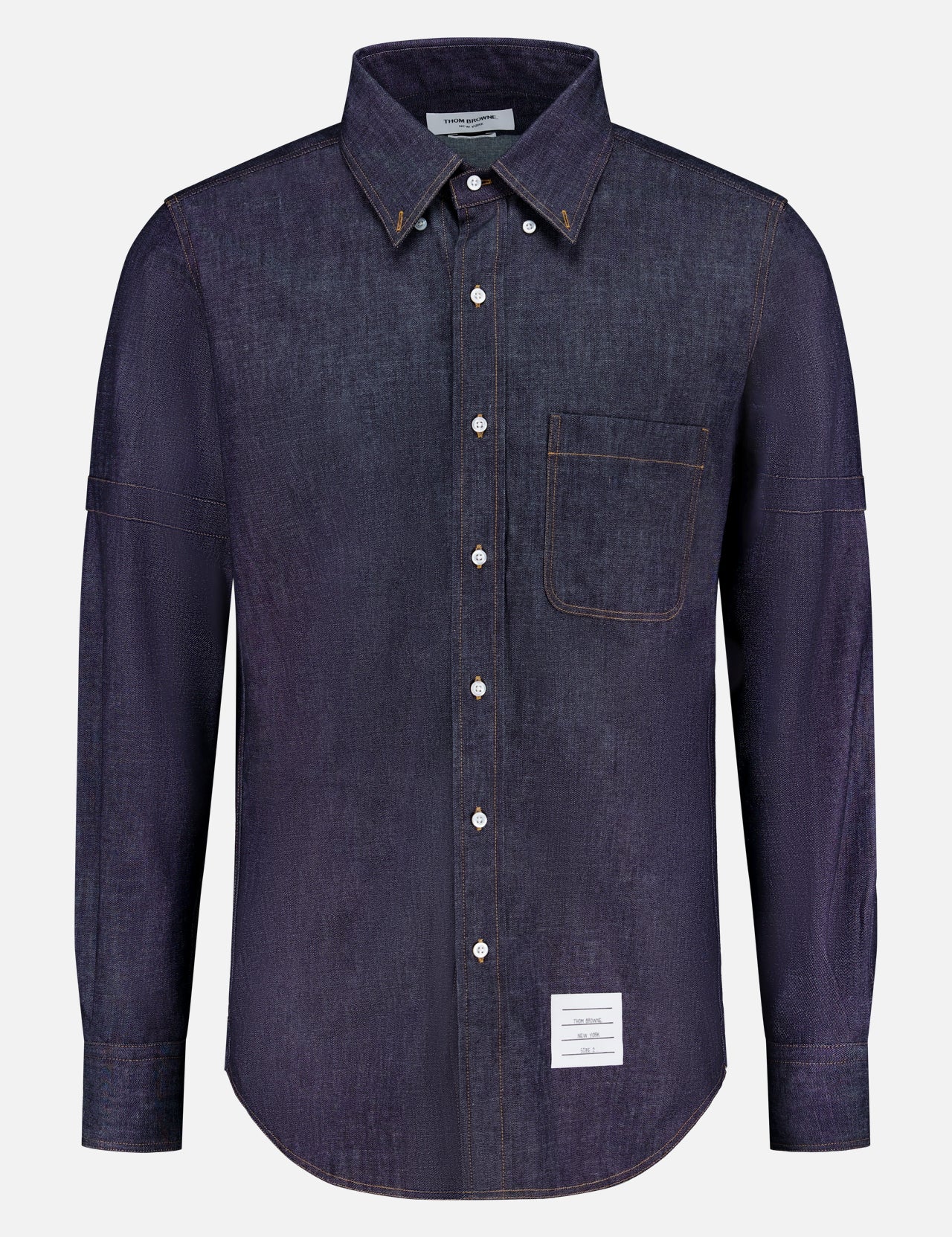 The THOM BROWNE Denim Long Sleeve Button Down Straight Fit Shirt features classic Americana style, a chest pocket, white buttons, and a small rectangular white label near the bottom hem.