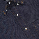 A close-up of the THOM BROWNE Denim Long Sleeve Button Down Straight Fit Shirt in dark cotton denim with white buttons, orange stitching, a pointed collar, and chest pocket—expertly made in Italy for a timeless Americana look.