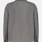 The Houndstooth Utility Patch Pocket Jacket by THOM BROWNE is a long-sleeved, black-and-white houndstooth shirt jacket shown from the back with a collar and buttoned cuffs.