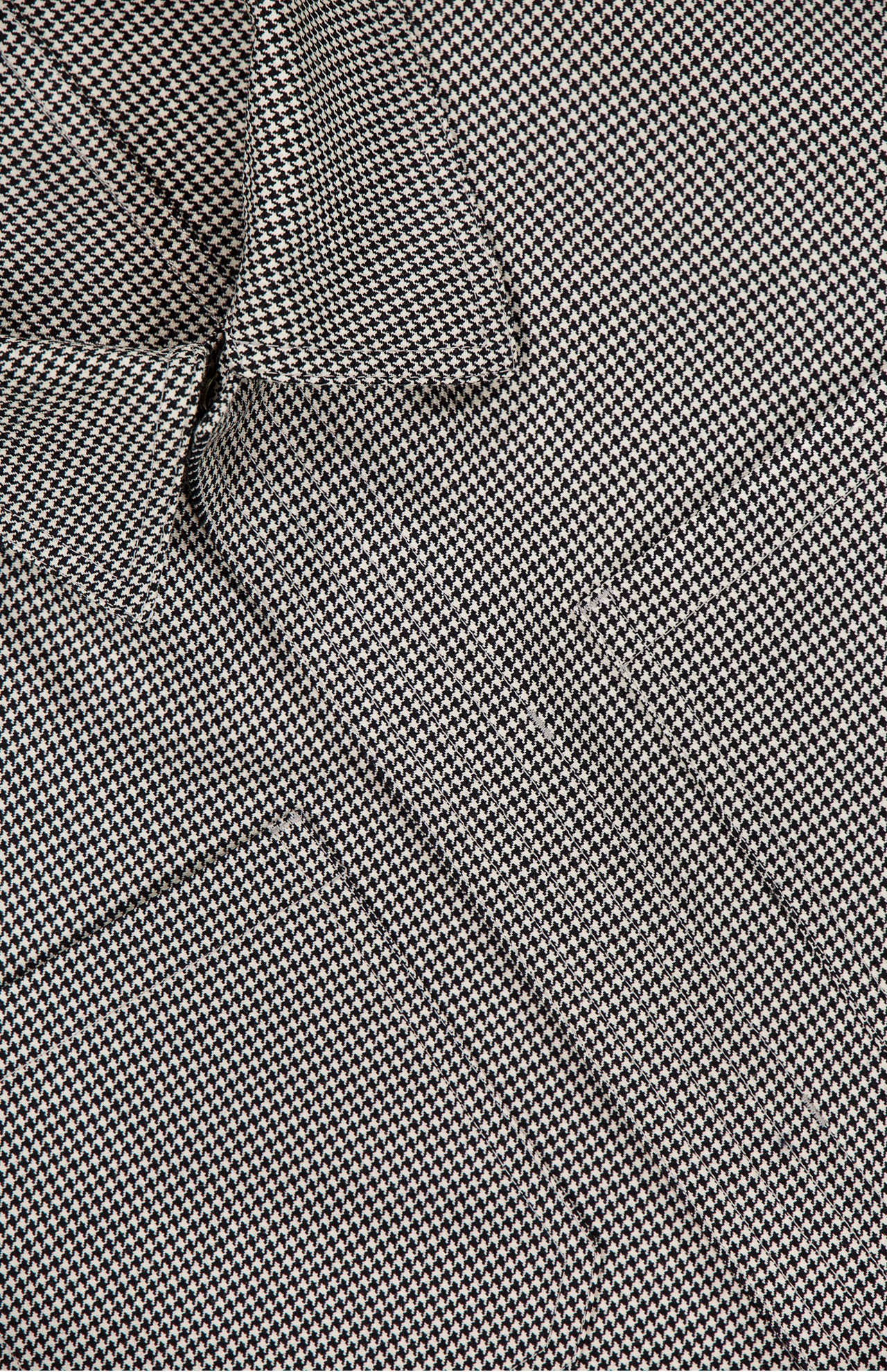 Close-up of the THOM BROWNE Houndstooth Utility Patch Pocket Jacket, featuring a small black and white houndstooth pattern with visible gentle folds and creases in the textured fabric.