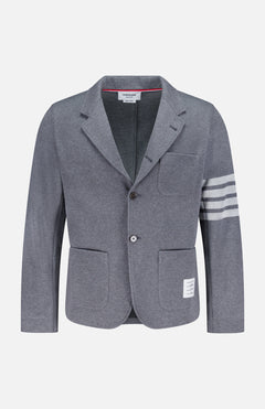 The THOM BROWNE Cotton Knit Sack Jacket is a grey single-breasted sportcoat with two buttons, three white stripes on the left sleeve, three front pockets, and a signature white label above the right pocket hem.