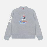The THOM BROWNE Stitched Boat Graphic Cardigan is a light gray coastal sweater featuring white stripes on one sleeve, an embroidered sailboat graphic on the back, and a red, white, and navy tab accent on the back collar.