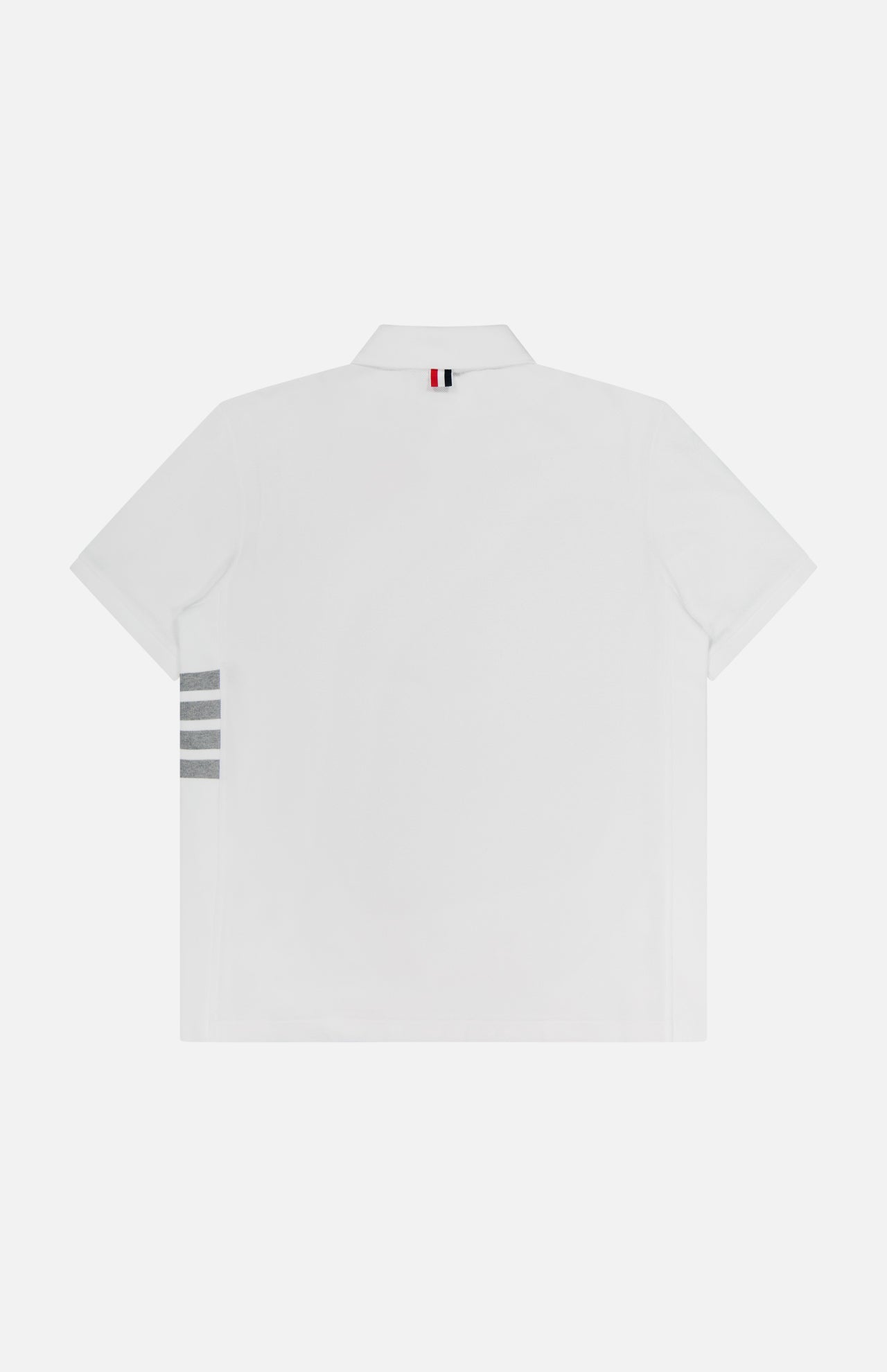 The THOM BROWNE Classic Pique Short Sleeve Rib Cuff Polo Shirt features classic Americana style with 100% cotton, three gray horizontal stripes on the left side, and a red, white, and blue striped loop below the collar.