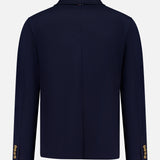 The THOM BROWNE Compact Milano Car Jacket is shown from the back in navy blue, featuring a notch collar and gold sleeve buttons. This men’s jacket captures classic Americana style, set against a plain white background.