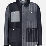 The Funmix Stripe Utility Patch Pocket Jacket by THOM BROWNE combines classic American menswear with a modern twist, featuring a long-sleeve, collared button-up design and a distinctive patchwork of vertical gray and black stripes, finished with four front utility patch pockets.