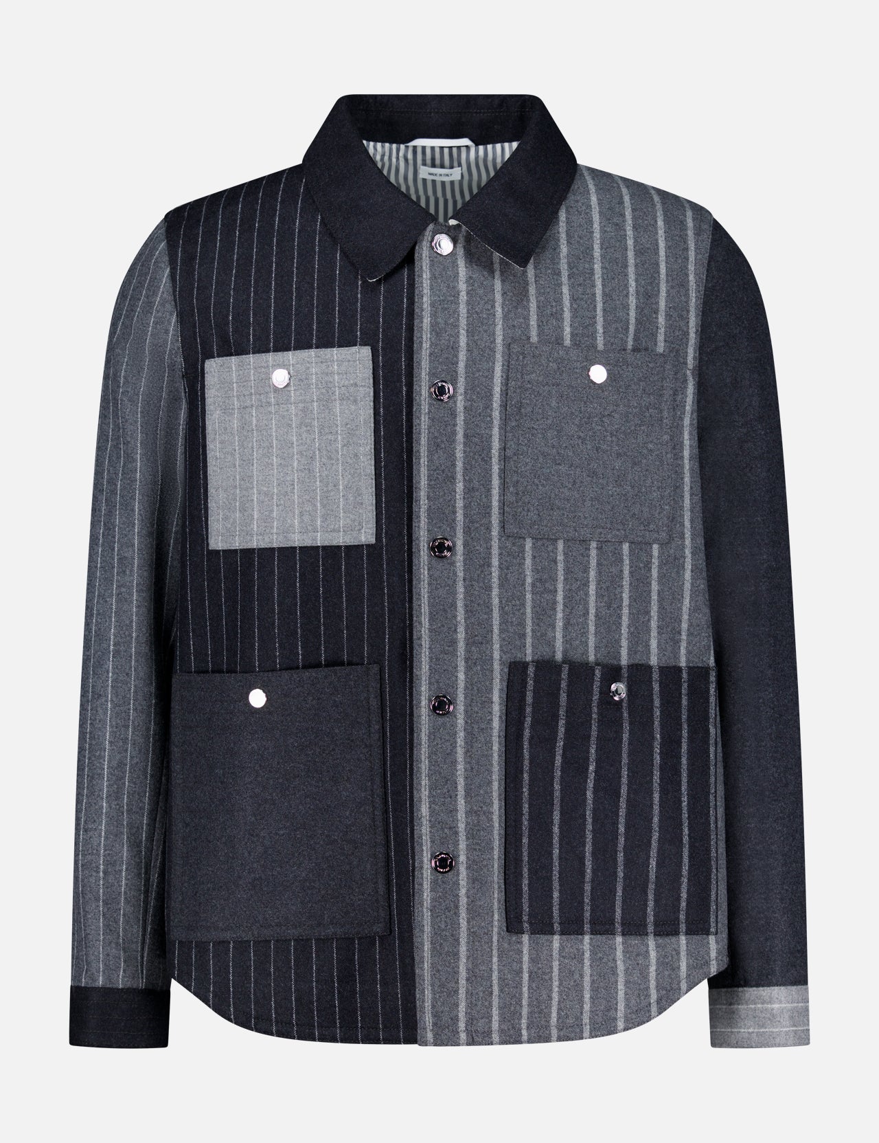 The Funmix Stripe Utility Patch Pocket Jacket by THOM BROWNE combines classic American menswear with a modern twist, featuring a long-sleeve, collared button-up design and a distinctive patchwork of vertical gray and black stripes, finished with four front utility patch pockets.