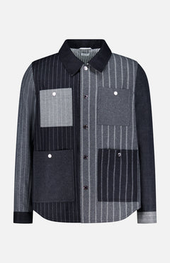 The Funmix Stripe Utility Patch Pocket Jacket by THOM BROWNE combines classic American menswear with a modern twist, featuring a long-sleeve, collared button-up design and a distinctive patchwork of vertical gray and black stripes, finished with four front utility patch pockets.
