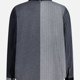 The Funmix Stripe Utility Patch Pocket Jacket by THOM BROWNE features a long-sleeve button-up design with a divided back: one side in solid dark gray, the other in light gray adorned with thin white pinstripes. Inspired by classic American menswear, this contemporary piece showcases a dark collar and left sleeve, while the right sleeve mirrors the pinstriped pattern for a bold, distinctive look.