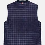 THOM BROWNE’s Houndstooth Teviot Tweed Snap Front Vest is a sleeveless vest featuring a navy blue and white houndstooth pattern, accented with a signature striped tab near the collar. Shown flat with the back facing up against a white background, this piece reflects an American sensibility through its timeless design.