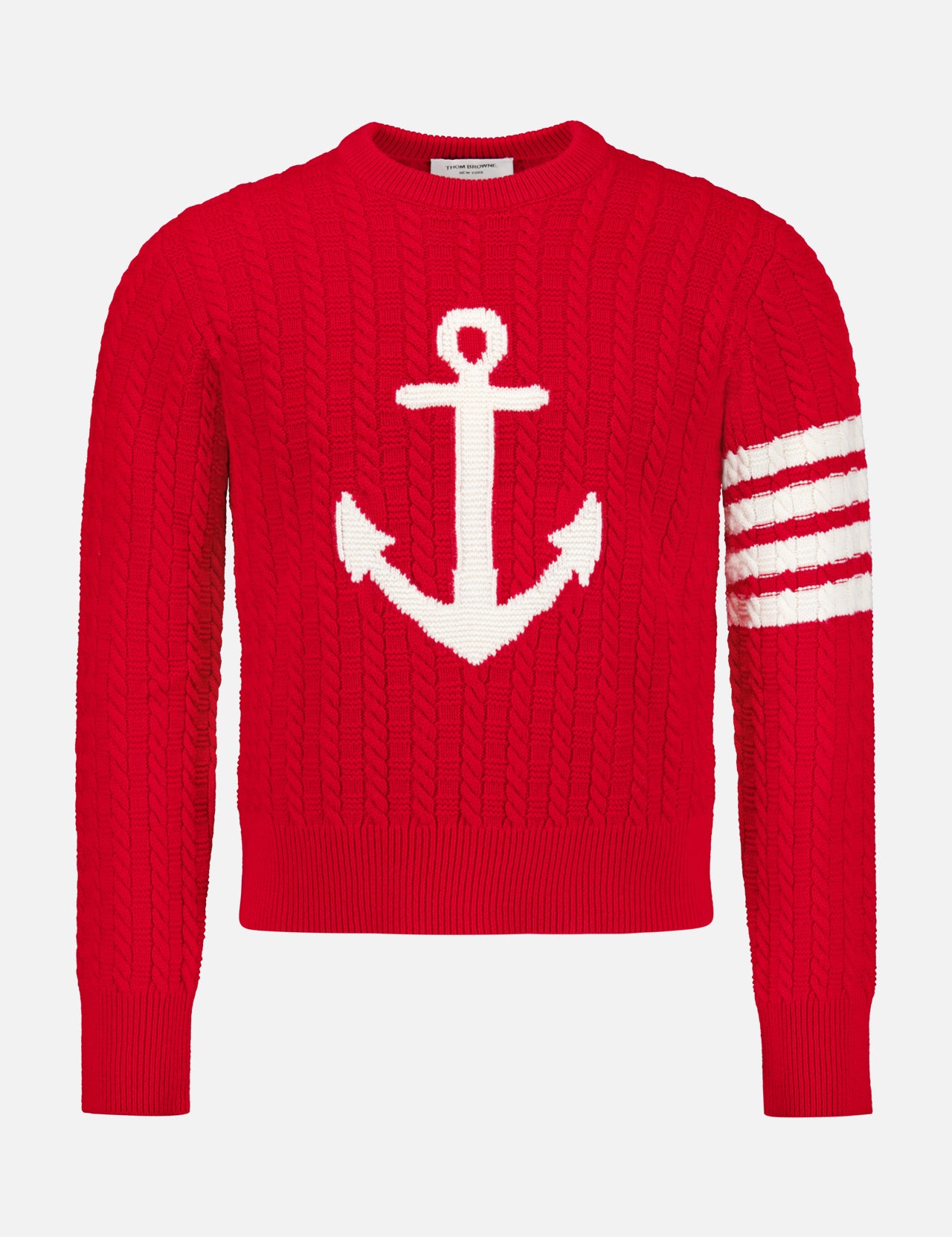 The Intarsia Anchor Merino Wool Crew Neck Sweater by THOM BROWNE is a bold red men’s sweater featuring a large white anchor intarsia on the front and three distinctive white stripes on one sleeve, offering timeless nautical style.