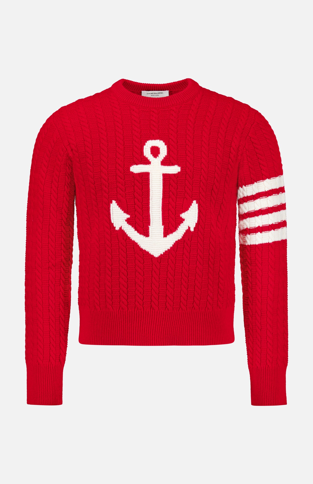 The Intarsia Anchor Merino Wool Crew Neck Sweater by THOM BROWNE is a bold red men’s sweater featuring a large white anchor intarsia on the front and three distinctive white stripes on one sleeve, offering timeless nautical style.