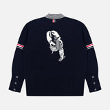The THOM BROWNE Jersey Stitch Lobster Cardigan is a navy sweater with white and red striped accents, a white jacquard lobster on the back, button-detailed cuffs, and a ribbed hem for classic Americana style.