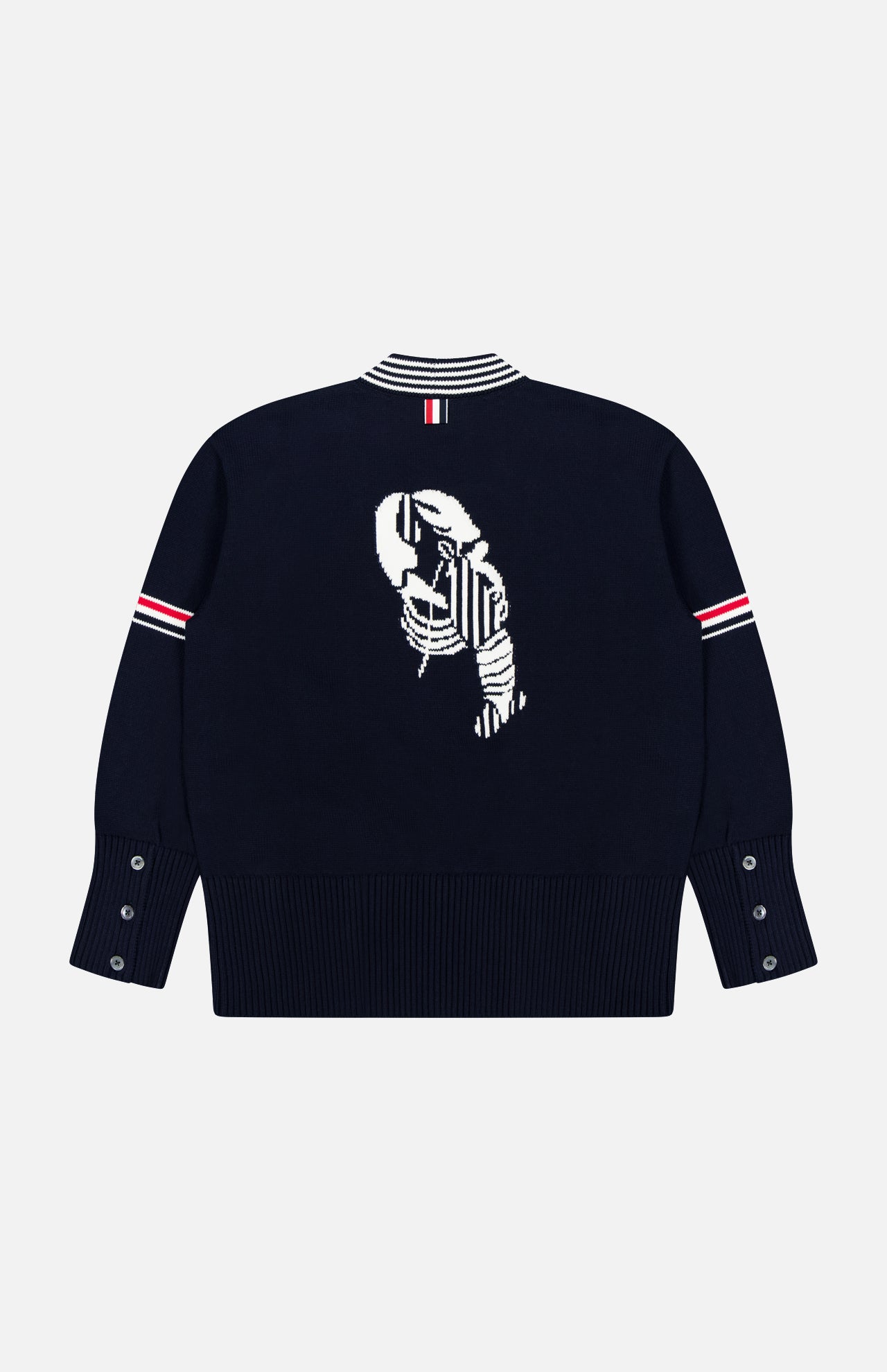 The THOM BROWNE Jersey Stitch Lobster Cardigan is a navy sweater with white and red striped accents, a white jacquard lobster on the back, button-detailed cuffs, and a ribbed hem for classic Americana style.