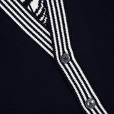 Close-up of the THOM BROWNE Jersey Stitch Lobster Cardigan for men, featuring a dark navy V-neck, black and white striped trim, two black buttons, partial white graphic at the top left, and a small pocket at the bottom.