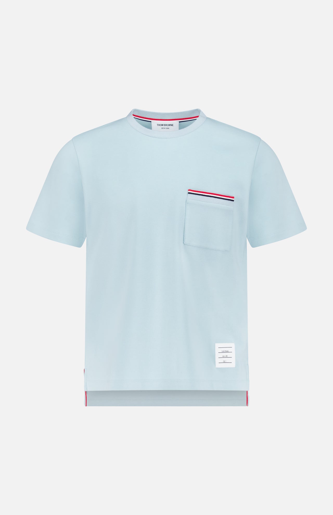 The THOM BROWNE Milano Cotton Pocket Short Sleeve T-shirt is light blue with a front chest pocket trimmed in red, white, and navy, a crew neck, and a small white label near the hem for an Americana casual vibe.