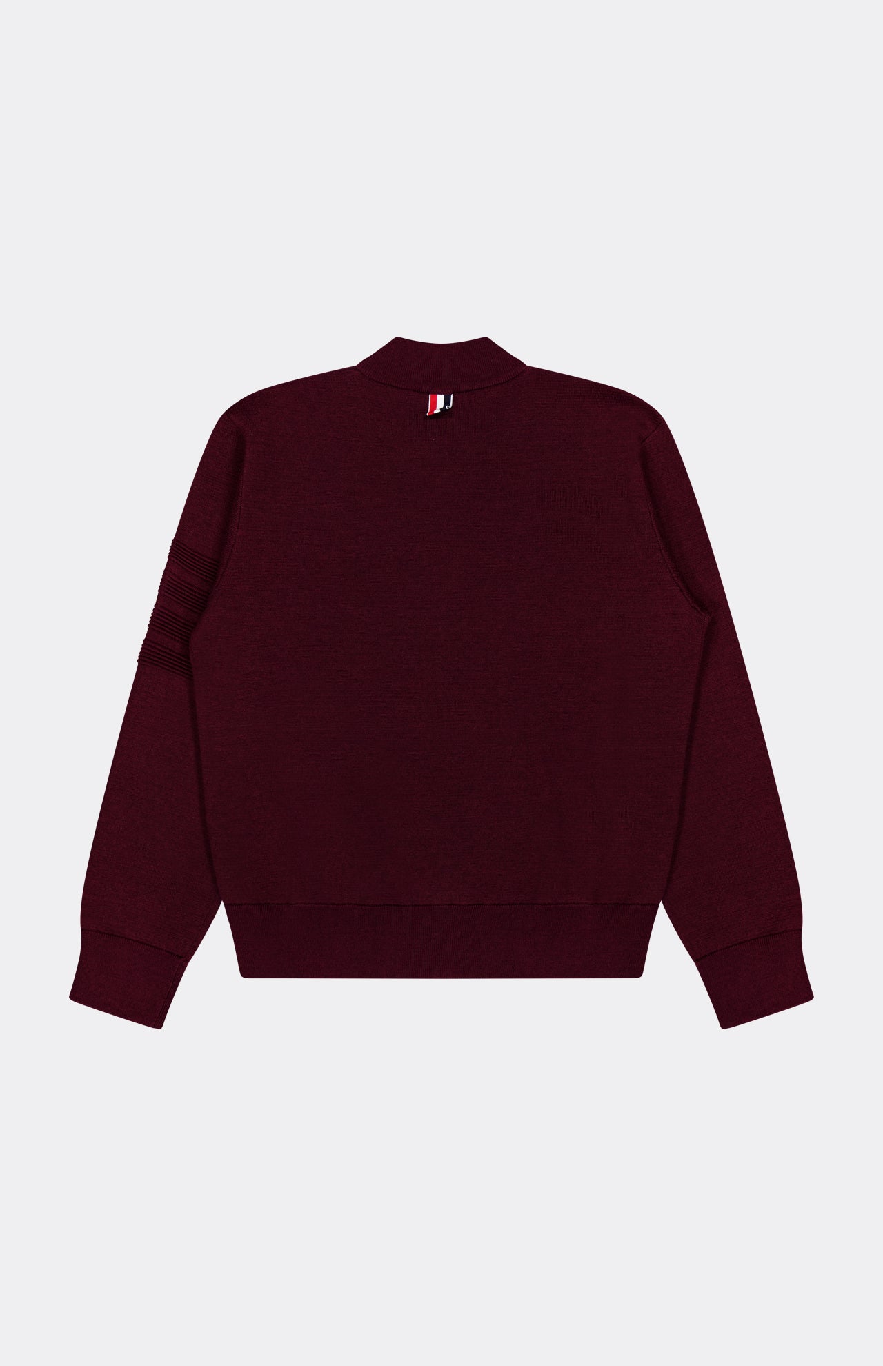 A back view of the THOM BROWNE Milano Stitch Zip Up Bomber Jacket in maroon highlights its ribbed cuffs and hem, along with a small red, white, and black striped tag near the collar—a subtle nod to Americana zip-up style.