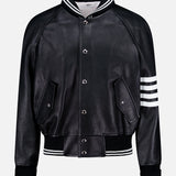 The Oversized Deerskin Leather Bomber Jacket by THOM BROWNE features black leather, white striped ribbed collar, cuffs, hem, left sleeve detail, button closures, and two angled front pockets—an Americana-inspired classic.