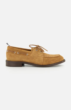 The THOM BROWNE Padded Boat Suede Loafer is a tan men's slip-on with brown laces, metal eyelets, and a low dark brown heel, shown in side profile on a white background.