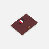 The THOM BROWNE Pebble Grain Leather Card Holder features four card slots, gold embossed details, and a red, white, and navy striped fabric tab. Shown on a white background for a refined look.