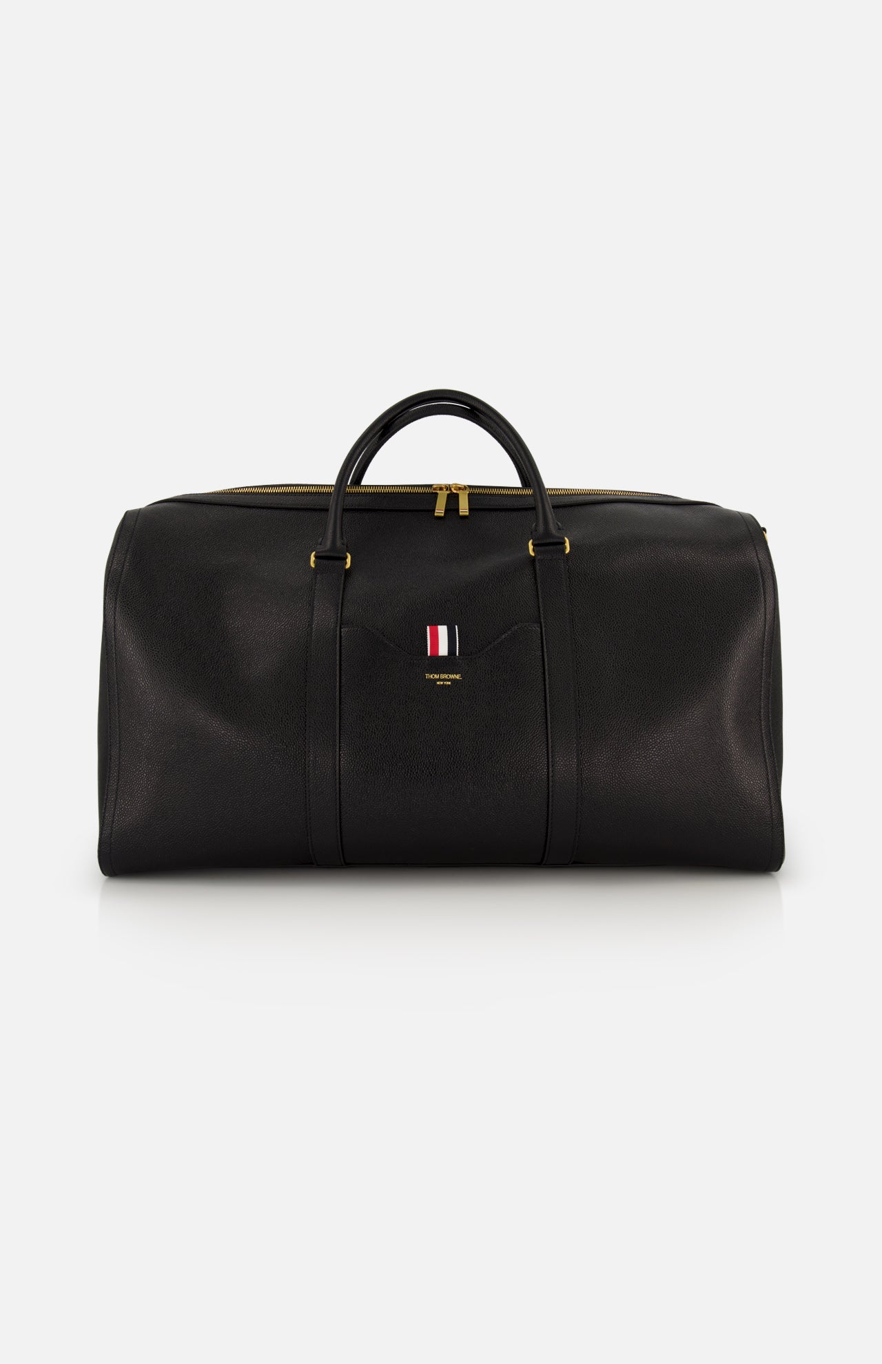 The THOM BROWNE Pebble Grain Leather Duffle Bag features black leather, gold zippers and hardware, two handles, and a front logo with red, white, and blue stripes—a stylish and convenient travel essential.