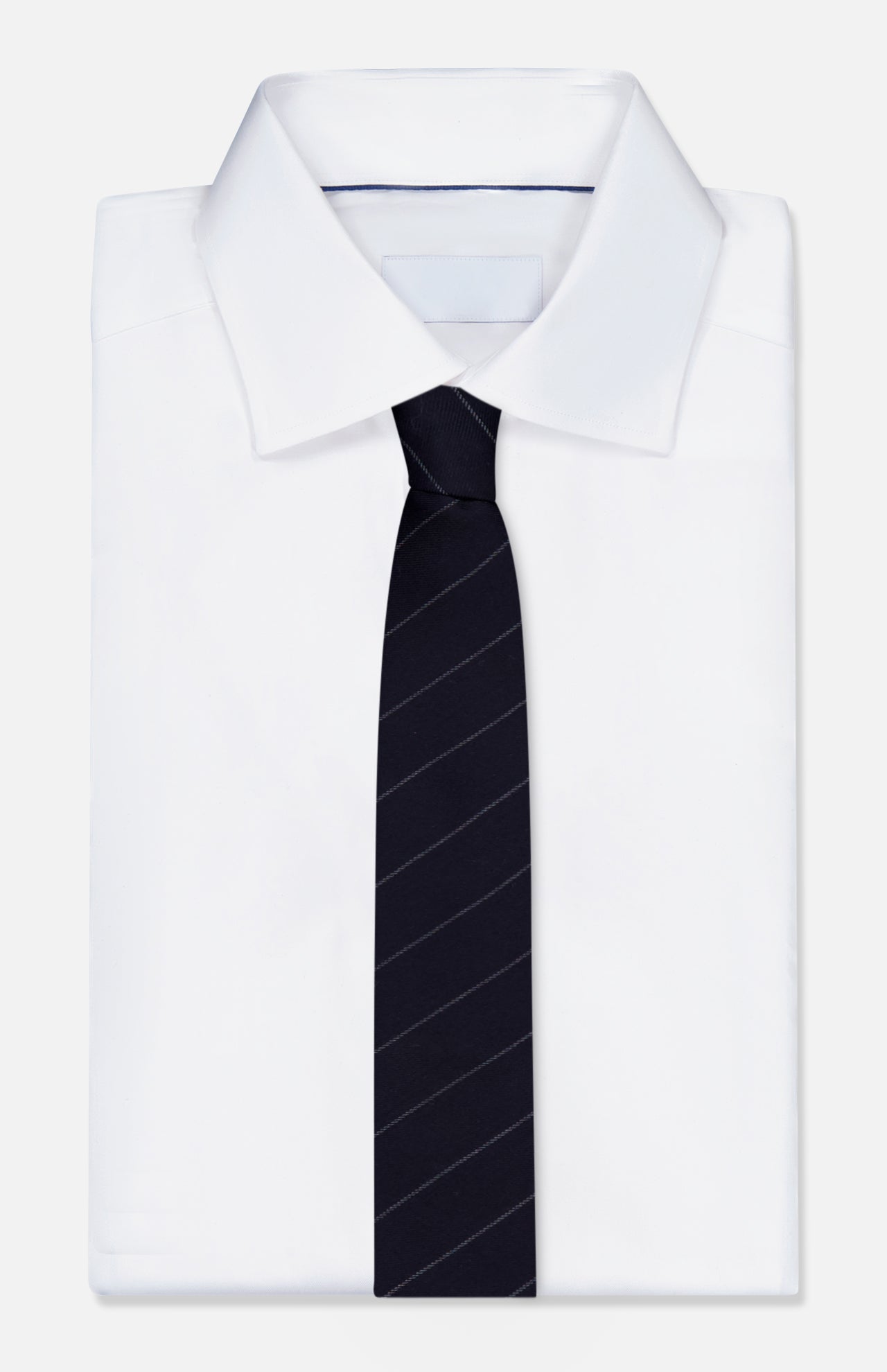 A neatly folded white dress shirt with a crisp collar is paired with the THOM BROWNE Pinstripe Wool Classic Tie—an Italian-made, dark navy tie featuring subtle diagonal pinstripes—displayed against a plain light background.