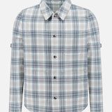 The THOM BROWNE Plaid Cotton Utility Patch Pocket Jacket is a blue, white, and gray long-sleeve plaid shirt jacket with a collar and chest pocket—versatile men’s outerwear ideal for layering year-round.