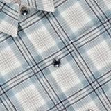 Close-up of the THOM BROWNE Plaid Cotton Utility Patch Pocket Jacket for men, featuring a gray and white plaid pattern, pointed collar, shiny round buttons, and soft lightweight fabric for versatile layering.