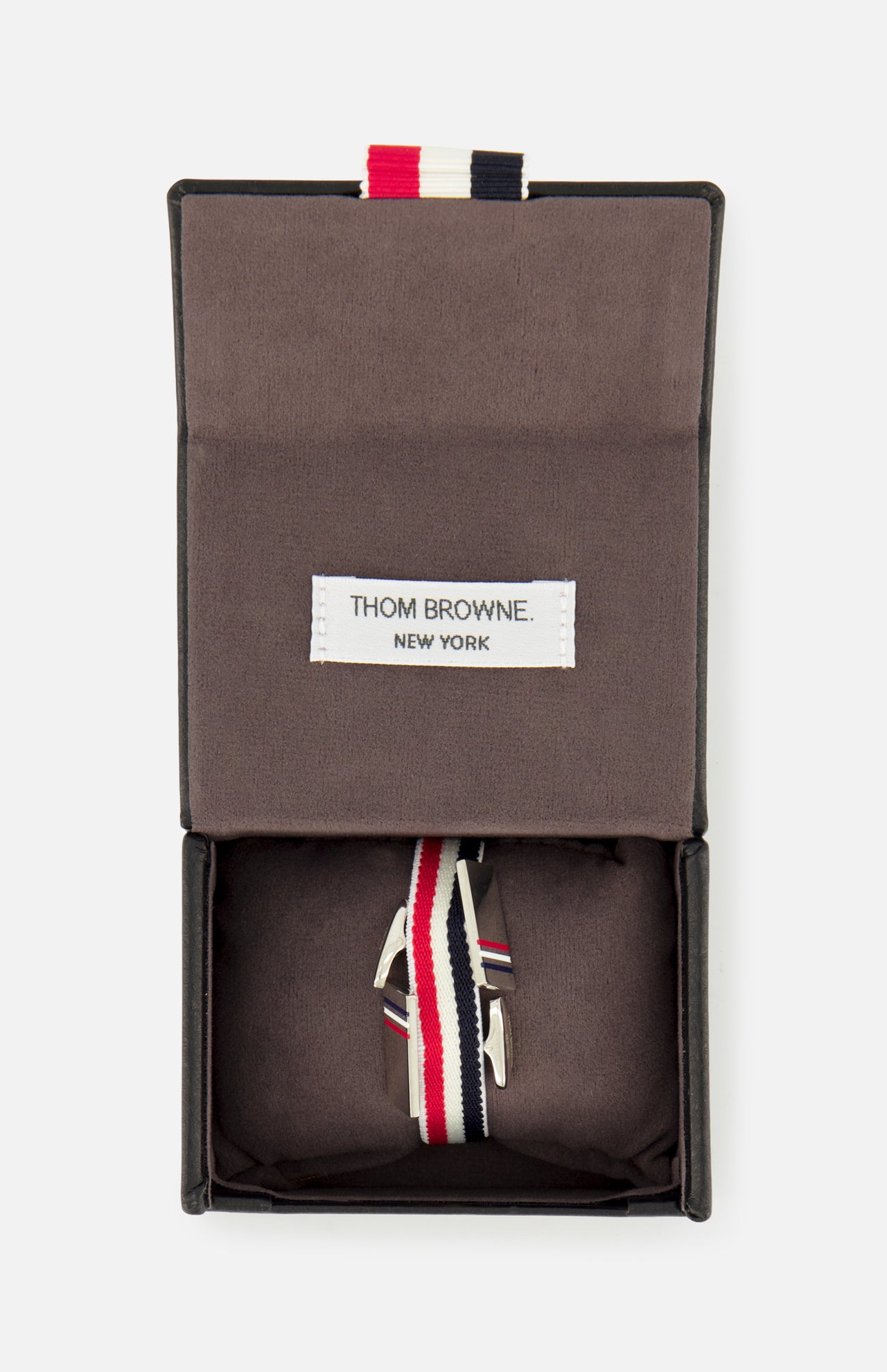THOM BROWNE RWB Enamel Cufflinks with red, white, and blue stripes are displayed in an open dark box with a fabric interior and a THOM BROWNE. NEW YORK label.