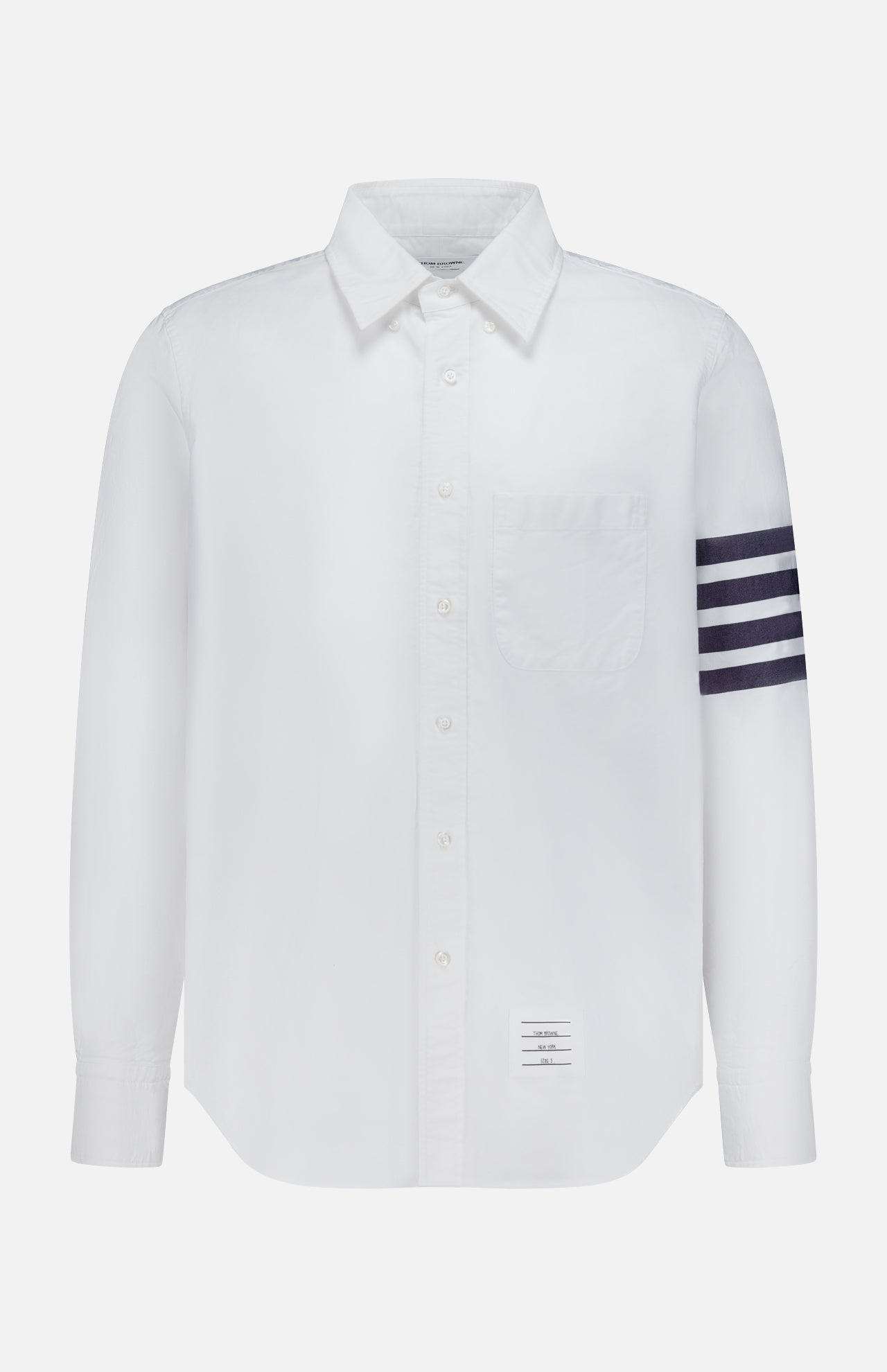 The THOM BROWNE Straight Fit 4 Bar Long Sleeve Oxford Shirt is a white shirt with a single chest pocket, four navy stripes on the left sleeve, and a signature rectangular label—blending classic Americana with modern menswear style.
