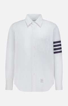 The THOM BROWNE Straight Fit 4 Bar Long Sleeve Oxford Shirt is a white shirt with a single chest pocket, four navy stripes on the left sleeve, and a signature rectangular label—blending classic Americana with modern menswear style.