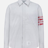 Introducing the Straight Fit Lobsters Long Sleeve Oxford Shirt by THOM BROWNE—a light blue and white pinstriped classic oxford shirt featuring a crisp collar and bold red horizontal bands with white detailing on the left arm. Finished with THOM BROWNE’s signature white rectangular label sewn near the bottom hem, this standout Americana piece is perfect for elevating your coastal summer wardrobe.