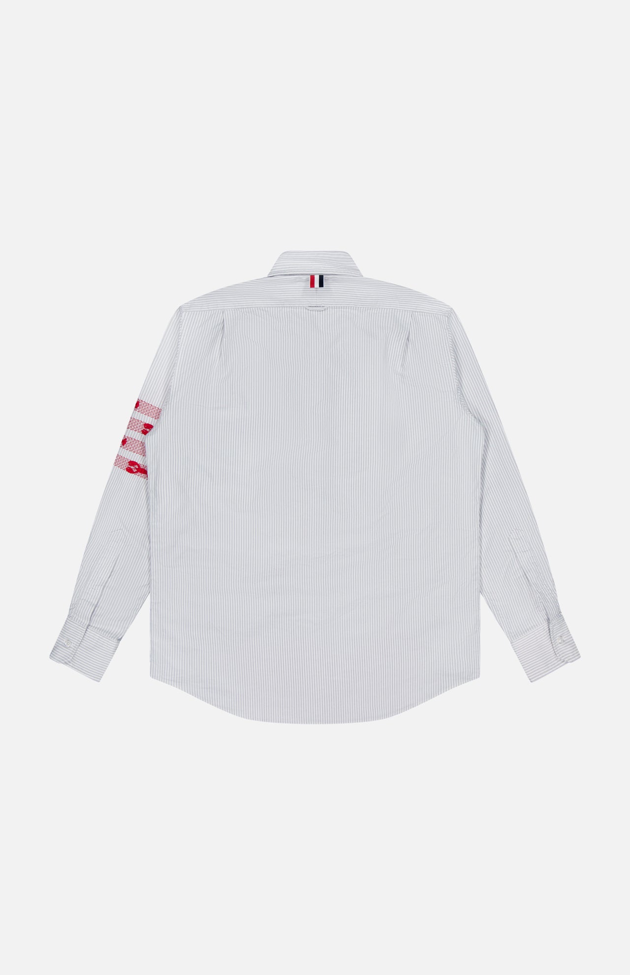A white, long-sleeve button-up oxford shirt by THOM BROWNE, the Straight Fit Lobsters Long Sleeve Oxford Shirt features subtle light blue pinstripes and is shown from the back. Red and white accents on the right sleeve and a small striped fabric tab near the collar lend an understated Americana touch to this classic dress shirt.