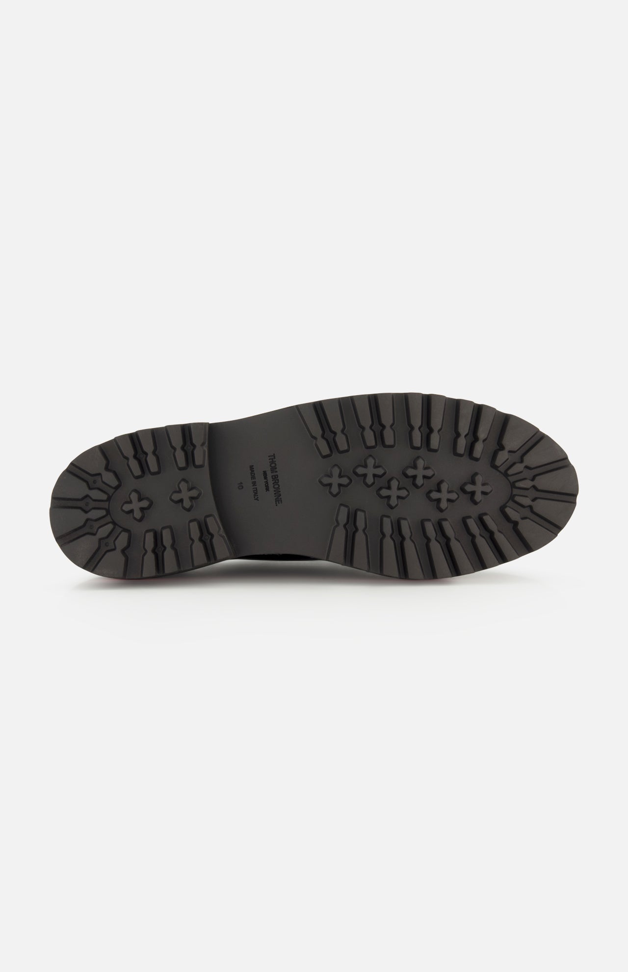 The image shows the underside of a black THOM BROWNE Vitello Calf Leather Derby Loafer sole, featuring thick, rugged tread patterns for traction plus text and sizing information printed in the center.
