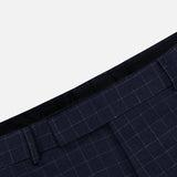 Close-up of the waistband of the THOM BROWNE Windowpane Check Cotton Wool Trouser Pant, featuring a light blue check pattern, belt loops, and pleats against a plain background.