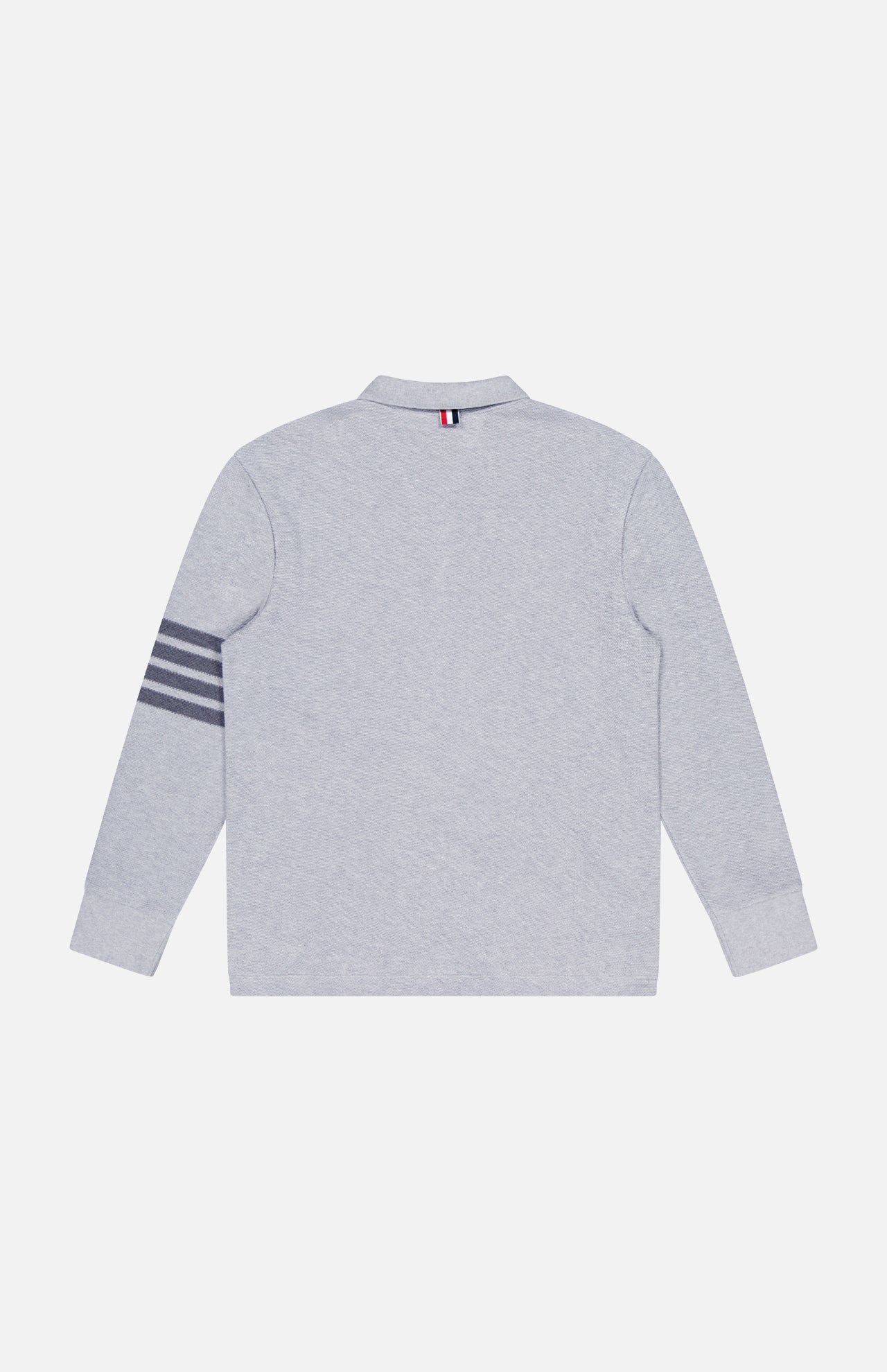 The THOM BROWNE Textured Pique Long Sleeve Polo Shirt in light grey is shown from the back, featuring four dark gray stripes on the left sleeve and a small tricolor tab at the center of the collar.