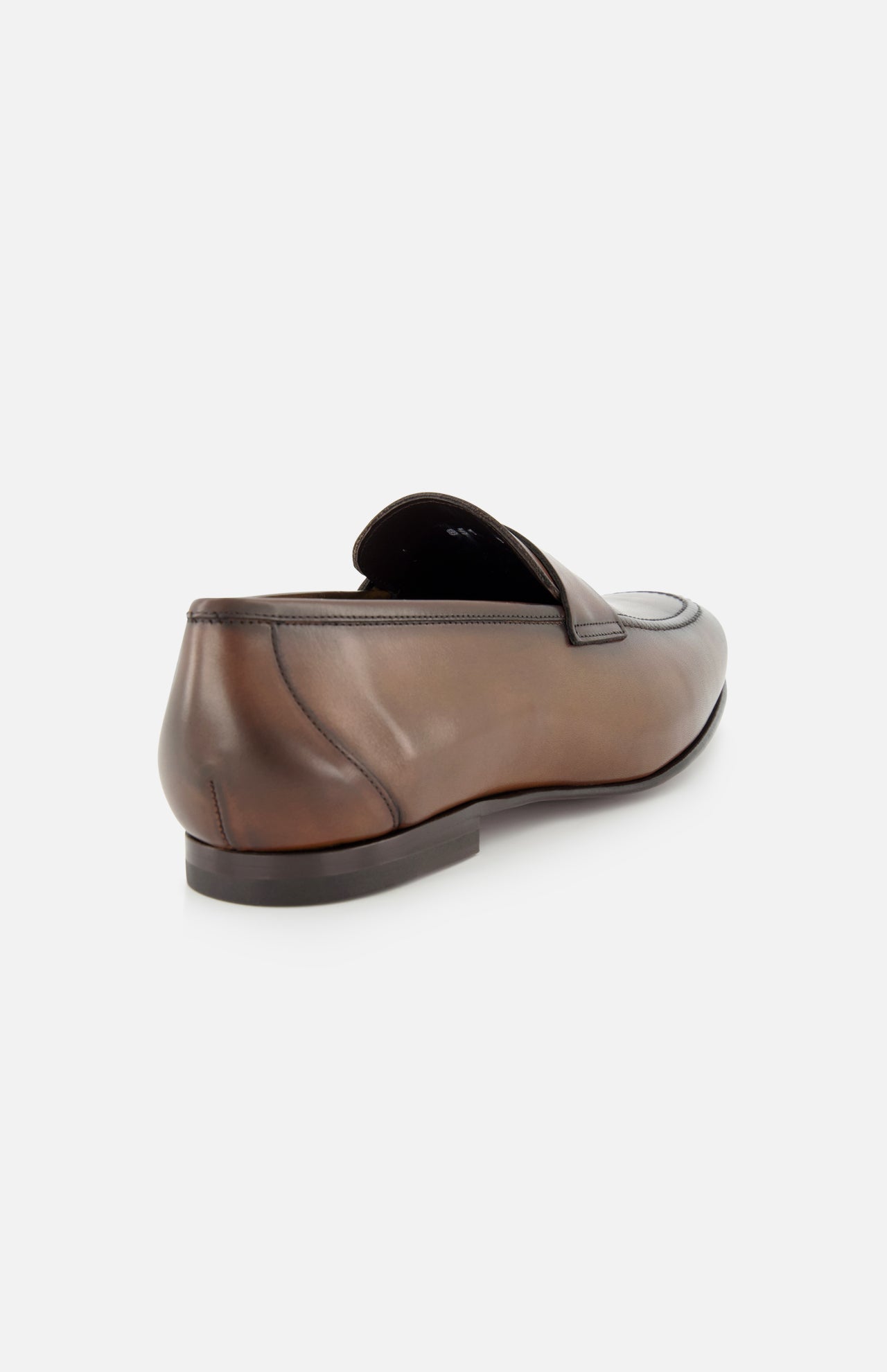 The TO BOOT Aldrin Leather Penny Loafer, shown from a rear side angle, highlights its brown leather finish, low black heel, and classic penny strap—a refined Italian-style shoe set against a light plain background.