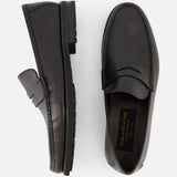 The TO BOOT Belfast Leather Loafer is shown in black leather, one upright and one flat to display the gold branded insole. These sleek, Italian-made loafers feature a low heel and textured sole.