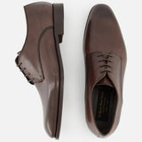 The TO BOOT Blakeley Leather Derby Oxford, a pair of brown leather lace-up shoes made in Italy, is shown from the side and top view on a plain white background.