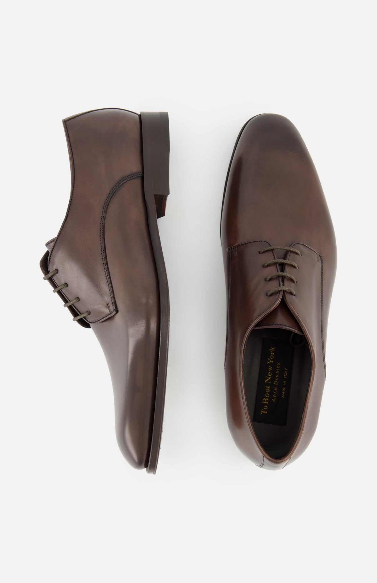 The TO BOOT Blakeley Leather Derby Oxford, a pair of brown leather lace-up shoes made in Italy, is shown from the side and top view on a plain white background.